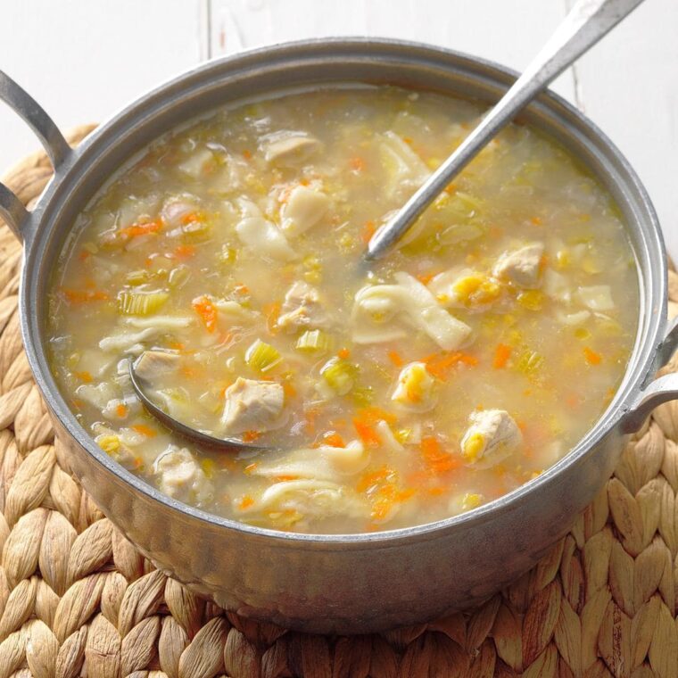 A bowl of soup and a spoon Description automatically generated