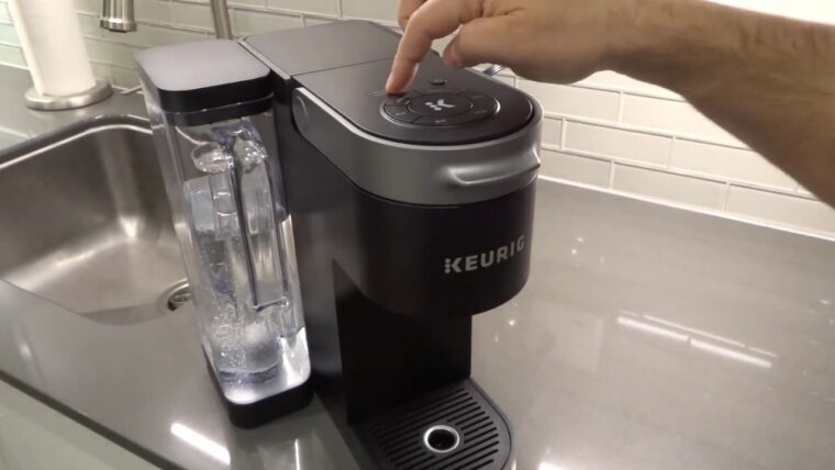 Hand pressing buttons on a Keurig coffee maker during descale mode