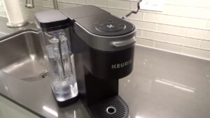 Keurig coffee maker on a kitchen counter with the water tank attached