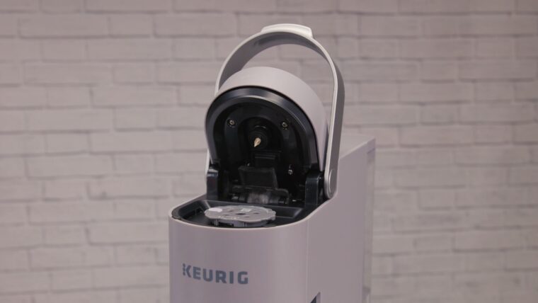 Open Keurig coffee maker with the pod holder visible